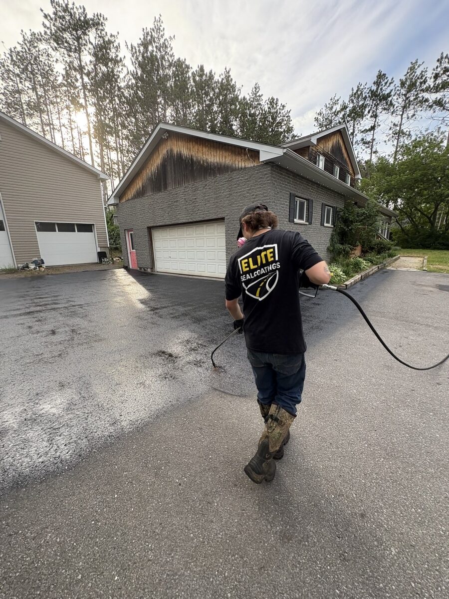 Elite Sealcoatings team member applying sealcoat